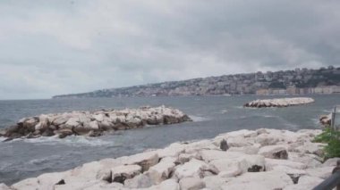 İtalya, Napoli yakınlarındaki Castel del Ovo 'da bir deniz duvarının yanında demirlemiş çeşitli küçük teknelerin bulunduğu huzurlu bir liman sahnesi. Yüksek kalite 4k görüntü