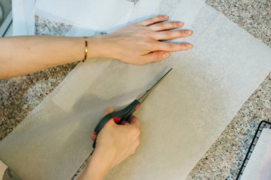 Pişirme tepsisini kağıdıyla doldur ve rulo makasıyla kes. Yüksek kalite fotoğraf