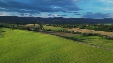 Gündoğumunda yeşil tepeleri ve tarım arazileri olan klasik Toskana manzarası. İtalya, Toskana 'daki yeşil yay tarlalarının ve tepelerin havadan görüntüsü. Yüksek kalite 4k görüntü