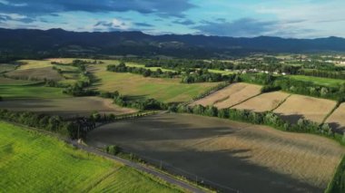 Gündoğumunda yeşil tepeleri ve tarım arazileri olan klasik Toskana manzarası. İtalya, Toskana 'daki yeşil yay tarlalarının ve tepelerin havadan görüntüsü. Yüksek kalite 4k görüntü