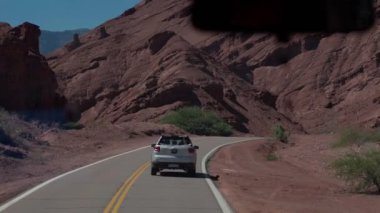 Arjantin, Jujuy 'da çölün ve dağların ortasından geçen popüler güzergah boyunca giden bir araba. Yüksek kalite 4k görüntü