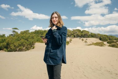 Akdeniz kıyısındaki güzel Patara plajında kum tepelerinde oturan genç bir kadın. Yüksek kalite fotoğraf