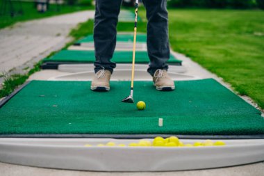 Golfçü macera ya da mini golf oynayıp topu deliğe sokmaya çalışıyor. Spor ve eğlence aktiviteleri. Yüksek kalite fotoğraf