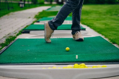 Golfçü macera ya da mini golf oynayıp topu deliğe sokmaya çalışıyor. Spor ve eğlence aktiviteleri. Yüksek kalite fotoğraf