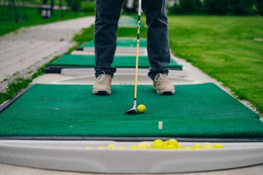 Golfçü macera ya da mini golf oynayıp topu deliğe sokmaya çalışıyor. Spor ve eğlence aktiviteleri. Yüksek kalite fotoğraf