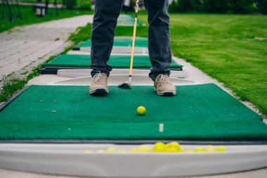 Golfçü macera ya da mini golf oynayıp topu deliğe sokmaya çalışıyor. Spor ve eğlence aktiviteleri. Yüksek kalite fotoğraf