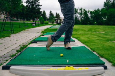 Golfçü macera ya da mini golf oynayıp topu deliğe sokmaya çalışıyor. Spor ve eğlence aktiviteleri. Yüksek kalite fotoğraf