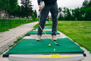 Golfçü macera ya da mini golf oynayıp topu deliğe sokmaya çalışıyor. Spor ve eğlence aktiviteleri. Yüksek kalite fotoğraf