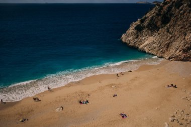 Türkiye 'nin Antalya bölgesi kıyılarında mavi suyu olan Kaputas plajı ve sahilde güneş şemsiyeleri. Hindi - Mayıs 2023. Yüksek kalite fotoğraf
