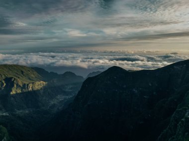 Güneşin ilk ışınlarının muhteşem doğal topoğrafyayı aydınlatan altın bir parıltıyla madeira dağlarının engebeli zirvelerini çarpıcı bir şekilde görüntülemesi. Yüksek kalite fotoğraf