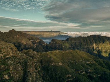 Güneşin ilk ışınlarının muhteşem doğal topoğrafyayı aydınlatan altın bir parıltıyla madeira dağlarının engebeli zirvelerini çarpıcı bir şekilde görüntülemesi. Yüksek kalite fotoğraf