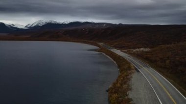 Alaska 'daki Kenai Yarımadası' nda sakin bir göl ve görkemli dağ zirveleri üzerinde dramatik ve karamsar bir gökyüzü. Yüksek kalite 4k görüntü