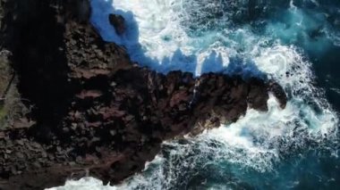 Okyanus dalgaları Hawaii 'de siyah bir bazalt kayaya vuruyor. Yüksek kalite 4k görüntü