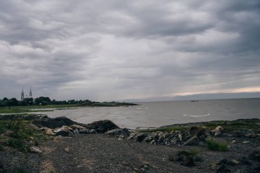 Yağmurlu bir günün ardından Quebec, Rimouski 'deki Pointe au Pere Deniz Feneri' nde St. Lawrence nehrinin üzerinde alevli bir gün batımı yaşandı. Yüksek kalite fotoğraf