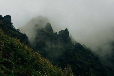Lai Chau, Vietnam 'daki Fansipan Dağı' nın zirvesinden göz kamaştırıcı manzara, yemyeşil dağların üzerinde yuvarlanan bulutları gösteriyor. Yüksek kalite fotoğraf