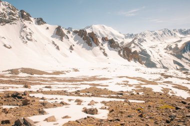 Orta Asya 'daki Tian Shan dağlarında bulutlu havada Almaty yakınlarında kaya ve buzla muhteşem bir dağ manzarası. Yüksek kalite fotoğraf