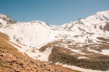 Orta Asya 'daki Tian Shan dağlarında bulutlu havada Almaty yakınlarında kaya ve buzla muhteşem bir dağ manzarası. Yüksek kalite fotoğraf