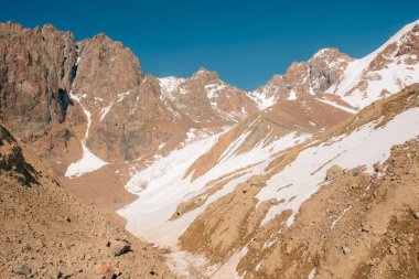 Orta Asya 'daki Tian Shan dağlarında bulutlu havada Almaty yakınlarında kaya ve buzla muhteşem bir dağ manzarası. Yüksek kalite fotoğraf