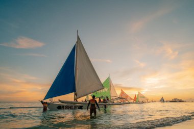 Boracay adası, Filipinler - 2 2025 Silhouetated people and palms near sea. Tropikal White Beach 'te gün batımı. Yüksek kalite fotoğraf
