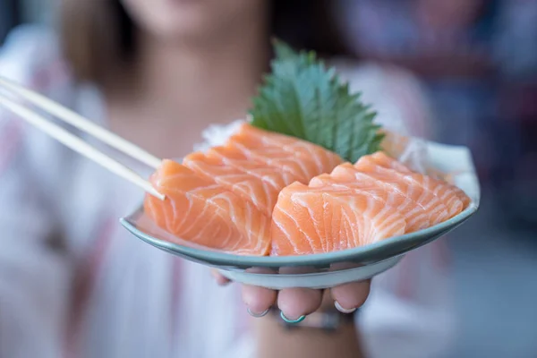 Japan raw salmon slice or salmon sashimi in japanese style. Salmon sasimi on hand.