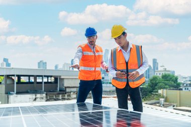 Mühendis ve İşçi güneş enerjisi panelini koruyor. Ustabaşı ve teknisyen güneş pili panellerini kuruyor veya onarıyor.