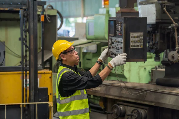 工程师负责监督检查工作的质量结果 男技术员在一家钢铁厂工作 钢制机器上戴安全帽的男工 — 图库照片