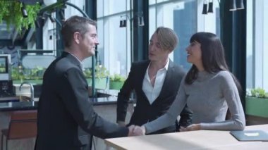 İş adamı el sıkışıyor. Toplantıdan önce insanlar ortak çalışma alanında tartışıyorlar. Ofis toplantısında birlikte çalışan iş arkadaşları..