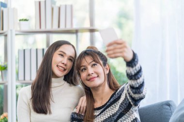 Lesbian Concept. Smiling beautiful Asian couple taking selfie. Couple doing self with mobile phone.