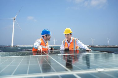 Güneş ve rüzgar çiftliği yenilenebilir enerji. Ustabaşı ve İşçi güneş enerjisi panelini koruyor.