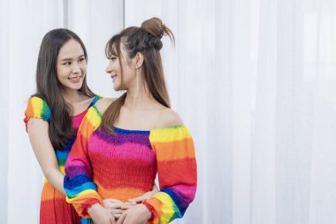 Happy lesbian couple in white bras hugging. Couple woman hugging each other together with rainbow dress.