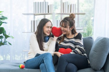 Lgbtqia Kavramı. LGBT toplumunu sembolize eden kırmızı bir kalp taşıyan iki genç kadın..