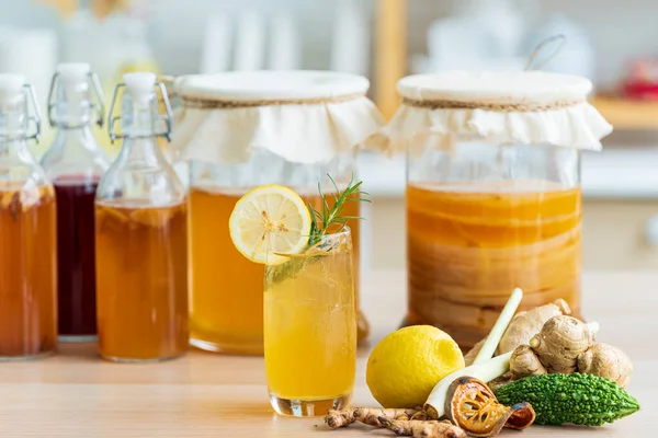 Bitkisel içecek. Limonlu kombu çayı ve mutfak arka planında cam sürahi doldurulmuş kök..