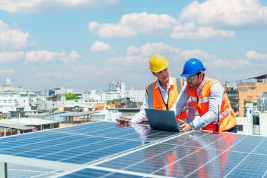 Foreman ve Worker güneş enerjisi panelini koruyorlar. Teknisyenler takıma liderlik etmek için güneş enerjili bir dizüstü bilgisayar kullanıyorlar..