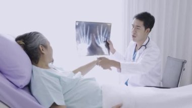 Hasta x-ray 'ini tutan uzman doktor hastalık teşhisini açıklıyor. Doktor, hastanedeki hasta için hastalık tedavi çözümünü açıkladı.