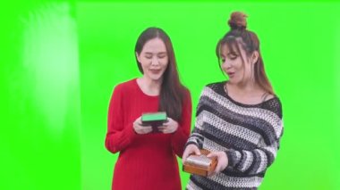 Yeşil ekranda kalimba çalan genç bir kadın. İki kadın müzik çalıyor..