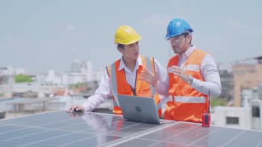 Foreman ve Worker güneş enerjisi panelini koruyorlar. Erkek mühendisler güneş paneli istasyonunun arızasını tartışıyor. Laptop ve tablet kullanan adam.