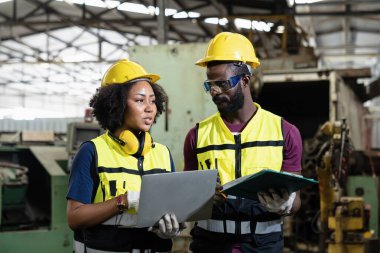Erkekler ve kadınlar endüstriyel fabrikalarda çalışıyorlar. Foreman, makinenin nasıl çalıştığını görmek için tahtayı eline al..