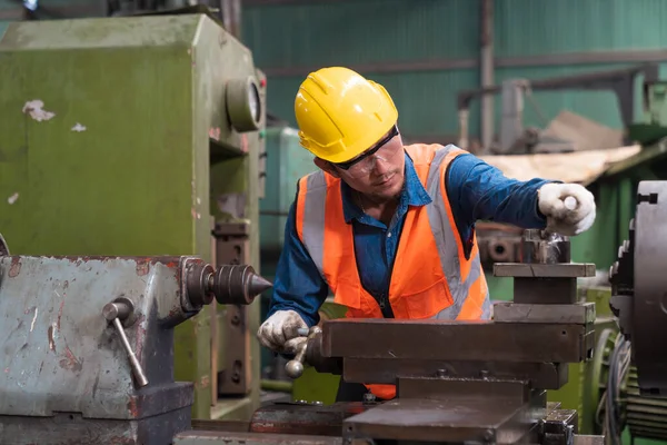 戴安全帽的男工在钢型机械上工作 技师和工程师正在工厂里操作和修理机器 — 图库照片