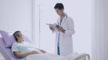 Doktor, hastanedeki hastaya hastalık tedavisi çözeltisini açıkladı. Hastanedeki Yaşlı Adam için Terapi.