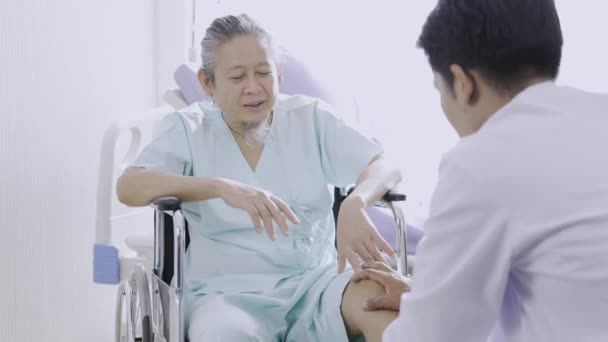 무릎에 통증을 느끼는 병원에 휠체어에 환자를 돌보고 아시아 — 비디오