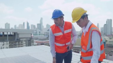 Temiz güneş paneli. Foreman ve Worker güneş enerjisi panelini koruyorlar. Güneş paneli teknisyeni çatıda.. 