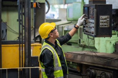 Staff or technicians are checking the operation of the old machine. Factory worker or engineer doing machine job in adept manufacturing workshop. clipart