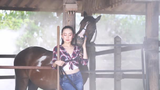 年轻的女人在马厩里和她的马在一起 开心地笑着 一个女人和她的马 — 图库视频影像