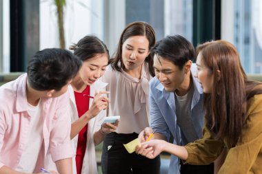 Grup Asyalı üniversite öğrencileri üniversitede birlikte zaman geçiriyorlar. İş adamları konuşuyor ve beyin fırtınası yapıyor..