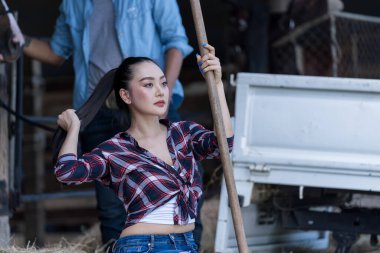 Genç bir kadın atıyla ahırda. At çiftliğinde hayvanları besleyen dişi çiftçi..