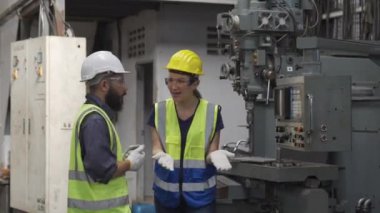 Torna operatörleri işe yoğunlaştı. Mühendislik ekibi başarısından gurur duyuyor. Üniformalı işçiler metal endüstrisi fabrikasında elle kumanda işliyor..