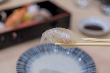 Japon yemeği tarzı. Beyaz balık suşisi. Çubuğun üzerinde yassı suşi..