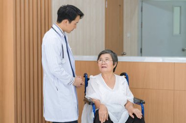 Profesyonel üniformalı doktor klinikteki ya da hastanedeki hastayı muayene ediyor..