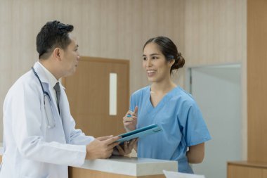 Doktorlar ve hemşire modern bir hastanede bir dosyanın içeriğini tartışıyorlar. Hastanedeki çeşitli tıp uzmanları....