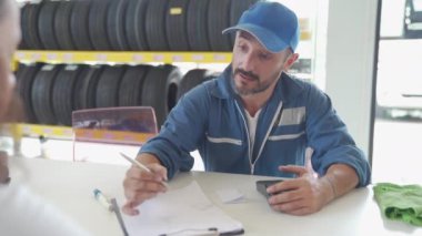 Araba tamirhanesinde kredi kartıyla genç bir kadının ödemesi. Kredi kartıyla ödeme.